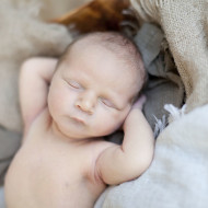 Newborn sleeping with hands behind head