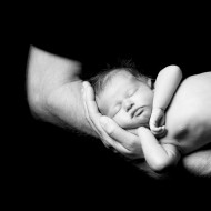 Newborn sleeping in dads arms