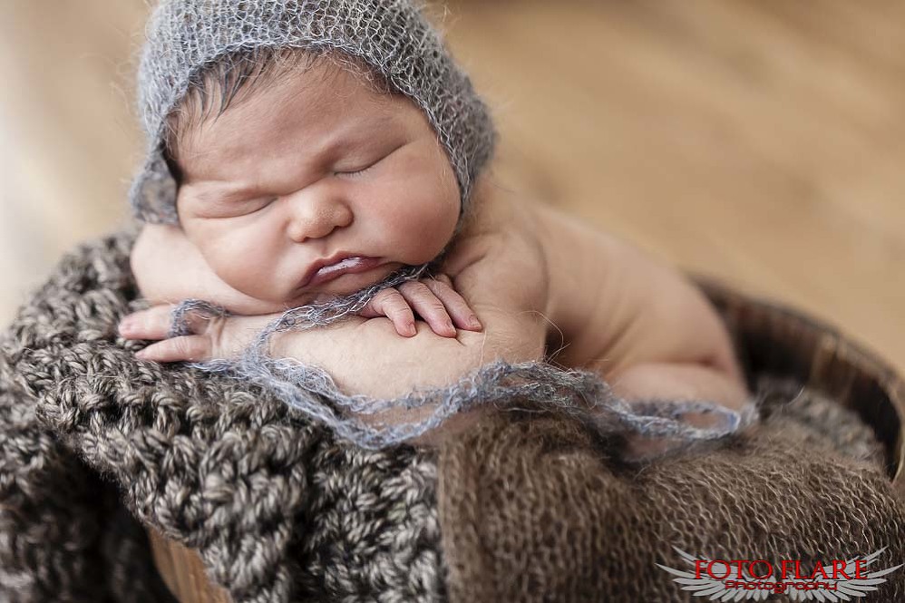 baby laying on on knitted blanket