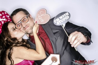 Photo booth image of a couple kissing with silly props