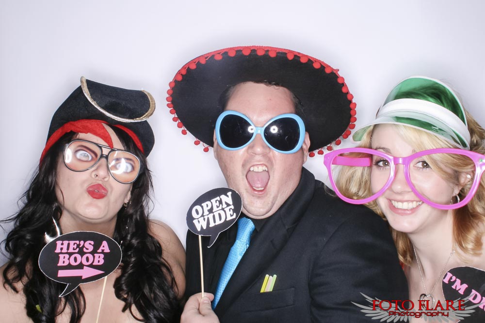 Silly wedding guests using photo booth props
