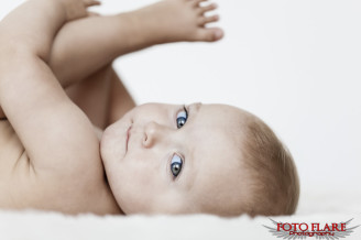 Toddler portrait playing with toes