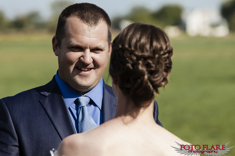 Groom smiling at his bride during outdoor ceremony