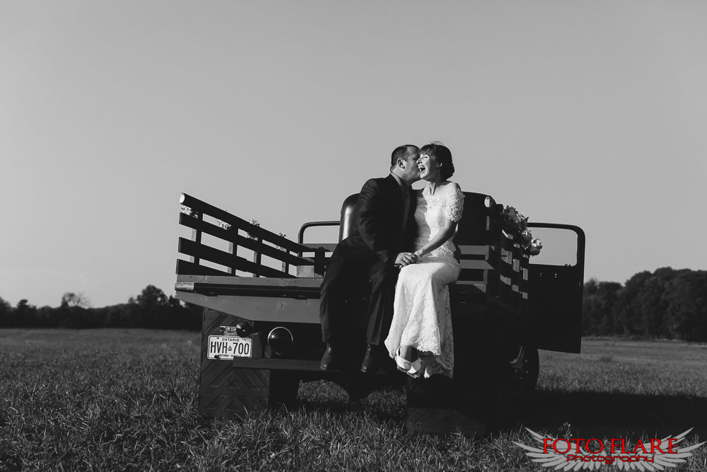 Bride and groom in the back of a flat bed ford truck