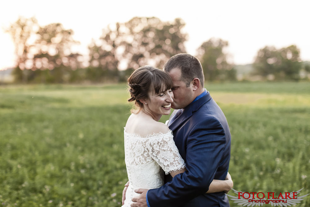 Evening wedding portraits of Dalton & Kate standing in a country field as the sun sets