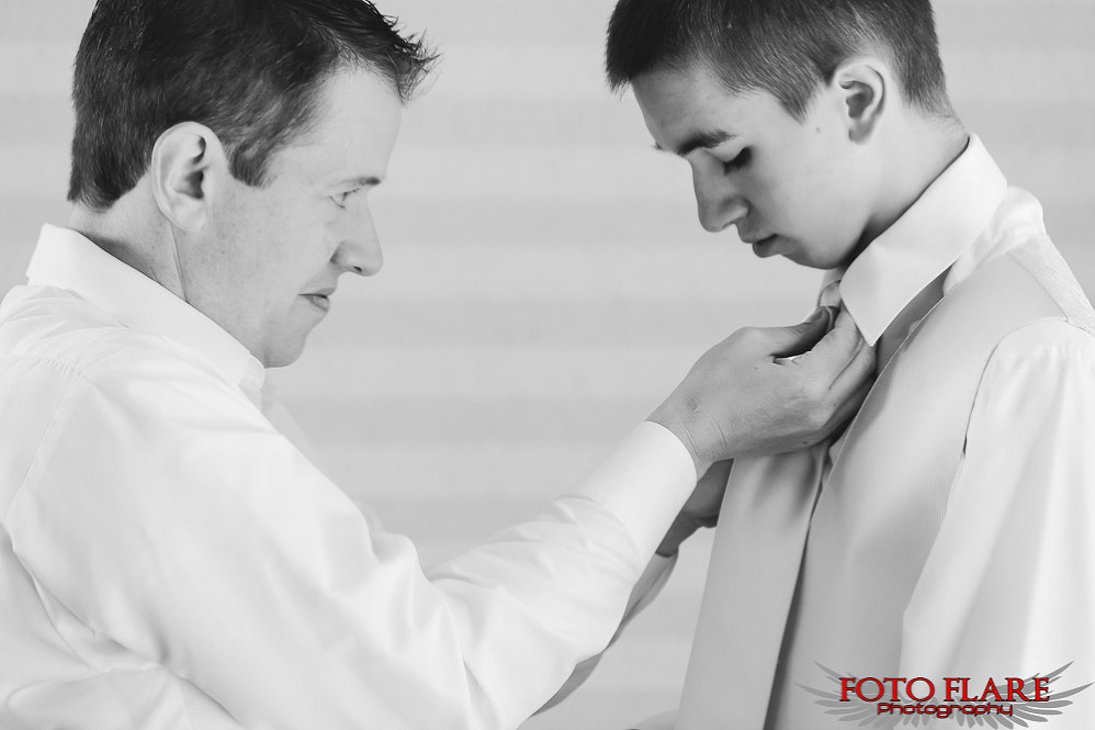 Groom helping son with tie