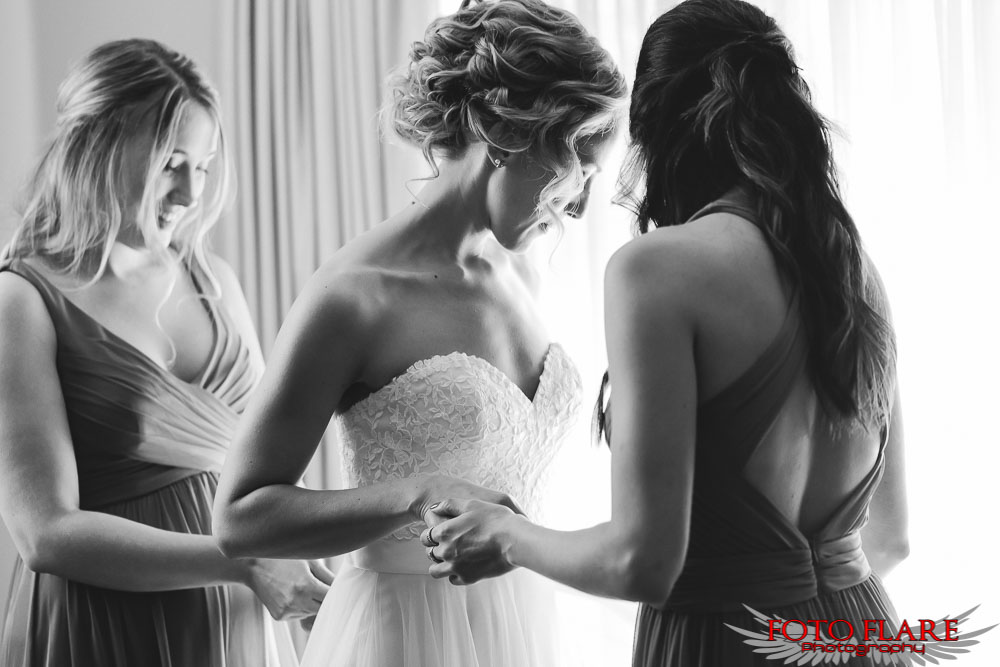 Bride getting help with her wedding gown