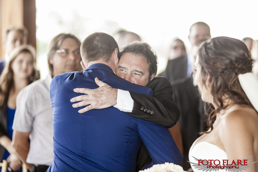 Brides father hugging groom