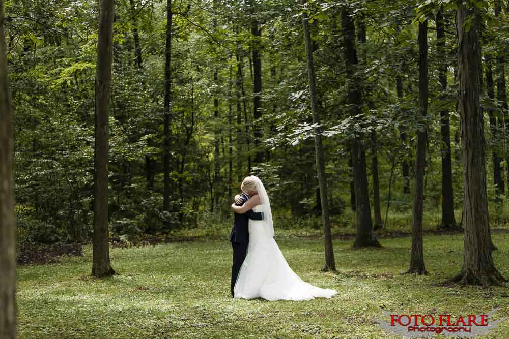 Bride and groom hugging in a open field