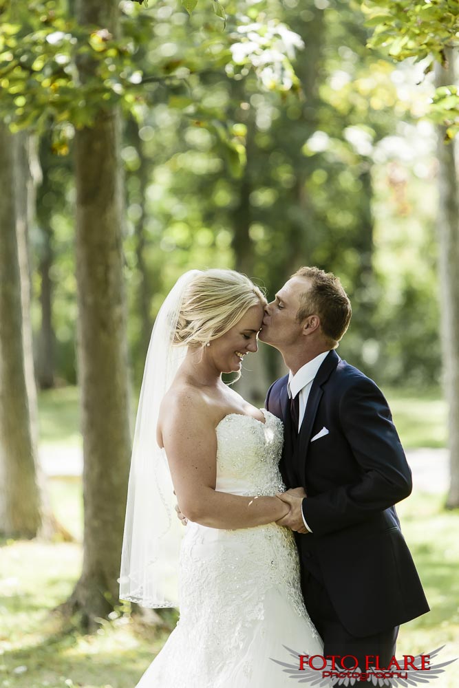 Groom kissing bride on forehead